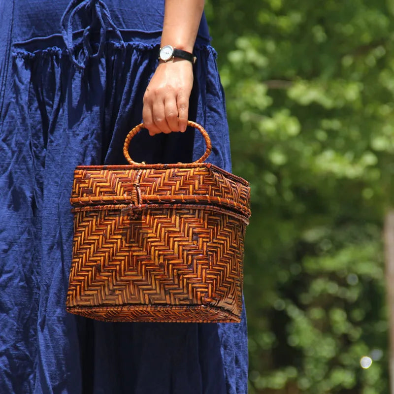 Person holding a woven basket with a blurred green background