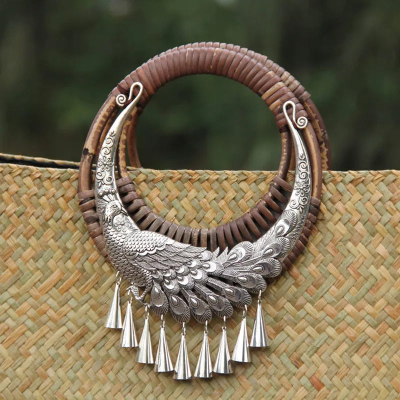 Decorative silver necklace with tassels on a woven surface
