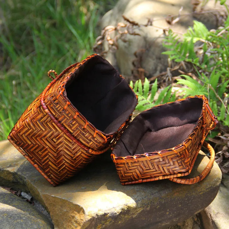 Woven brown basket with a dark interior on a stone surface with a natural background