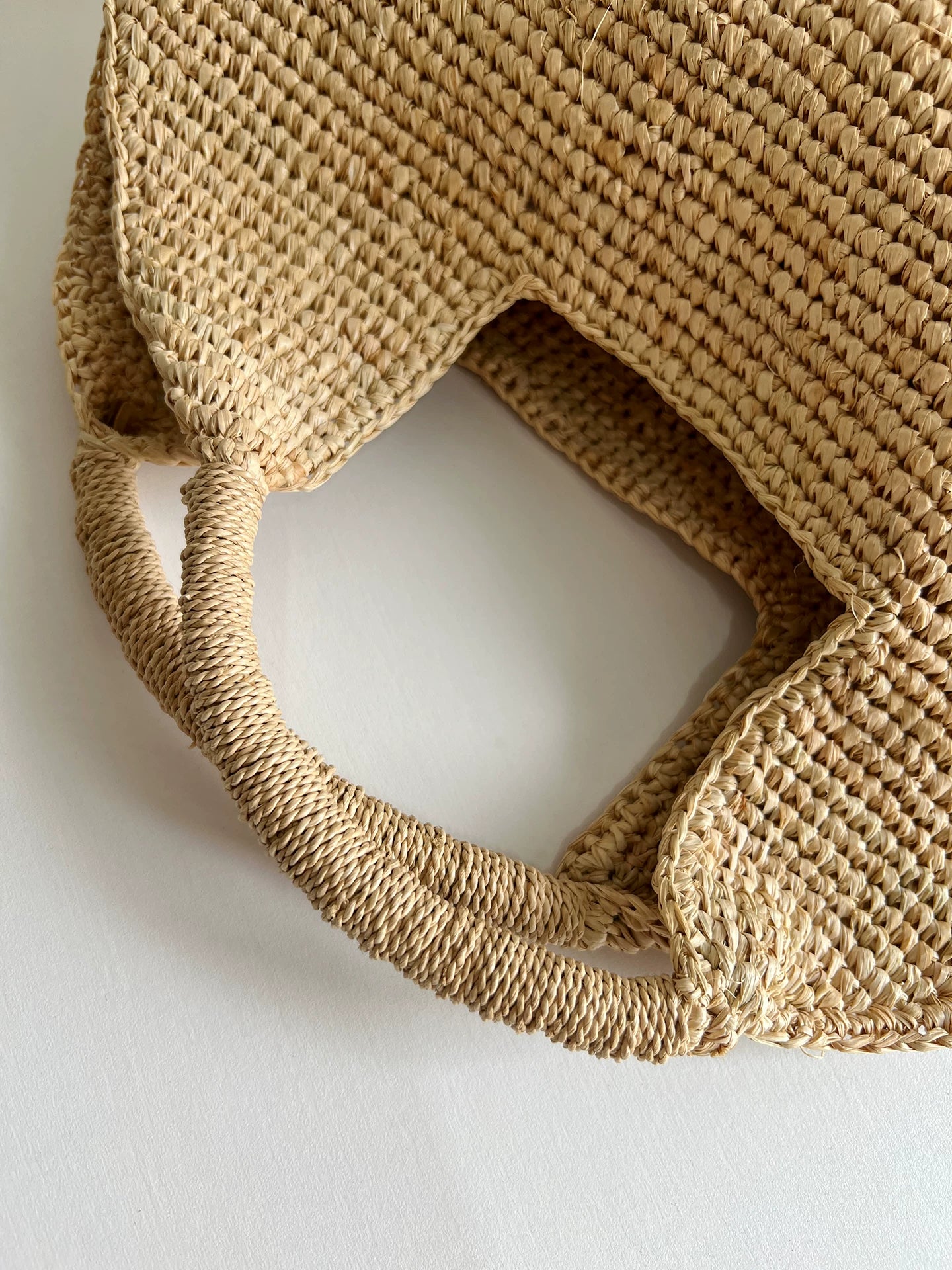 Close-up of a woven straw bag on a light background