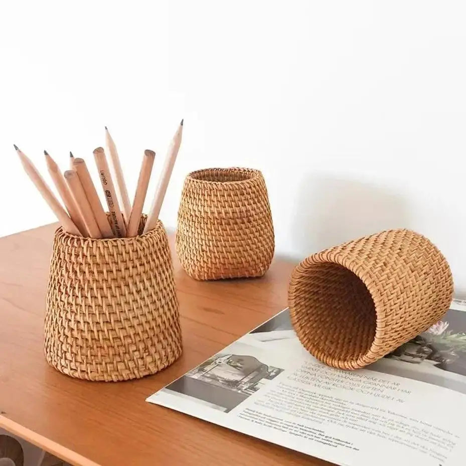 Woven rattan pencil holders on a desk with pencils and a magazine.
