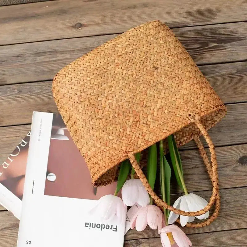 Woven basket with pink tulips on a wooden surface