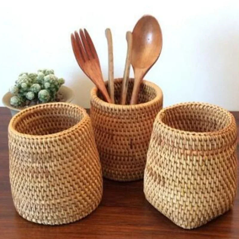 Three woven baskets with wooden utensils on a wooden surface.