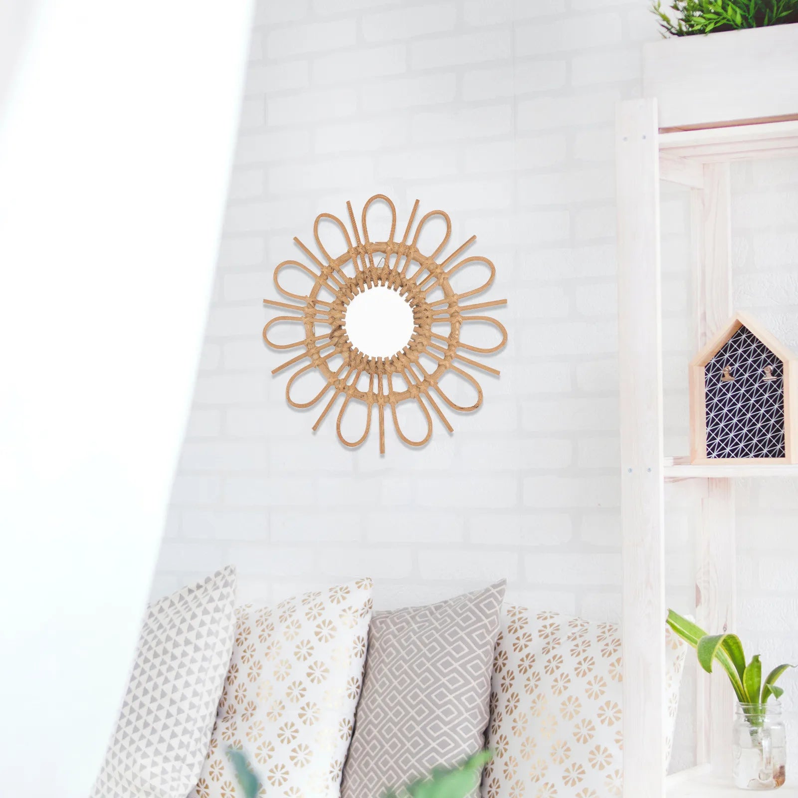 Decorative wall mirror with a sunburst design on a white wall above a sofa.