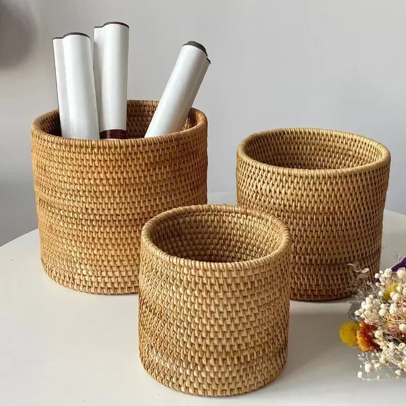 Three woven baskets of different sizes on a light surface with a neutral background