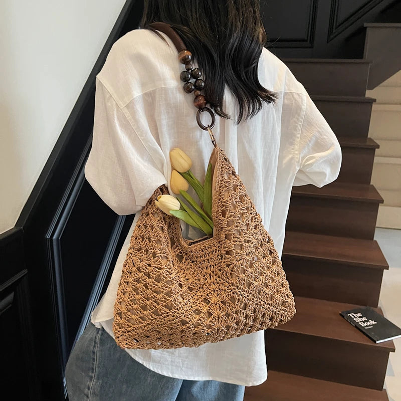 Person holding a woven bag with tulips against a staircase background