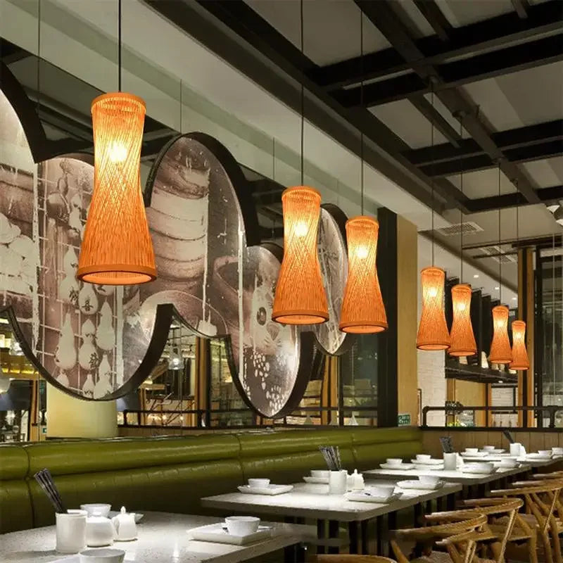 Modern restaurant interior with pendant lights, tables, and chairs.