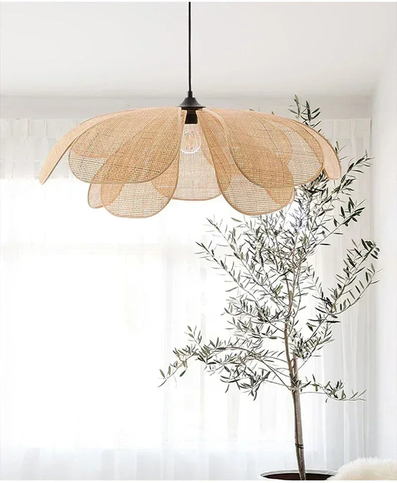 Decorative pendant light with a natural fiber shade next to a potted plant in a room.