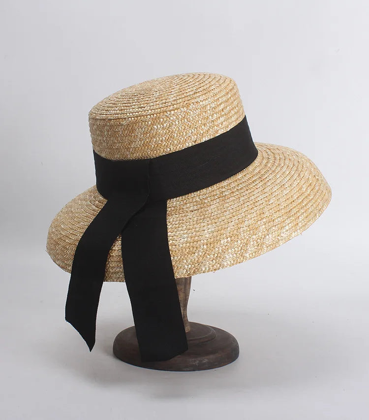Straw hat with a black ribbon on a gray background
