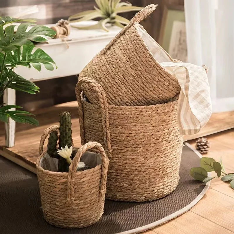 Two woven baskets on a wooden floor with plants around