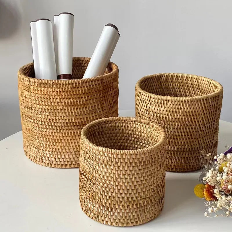 Three woven baskets of different sizes on a light surface with a neutral background