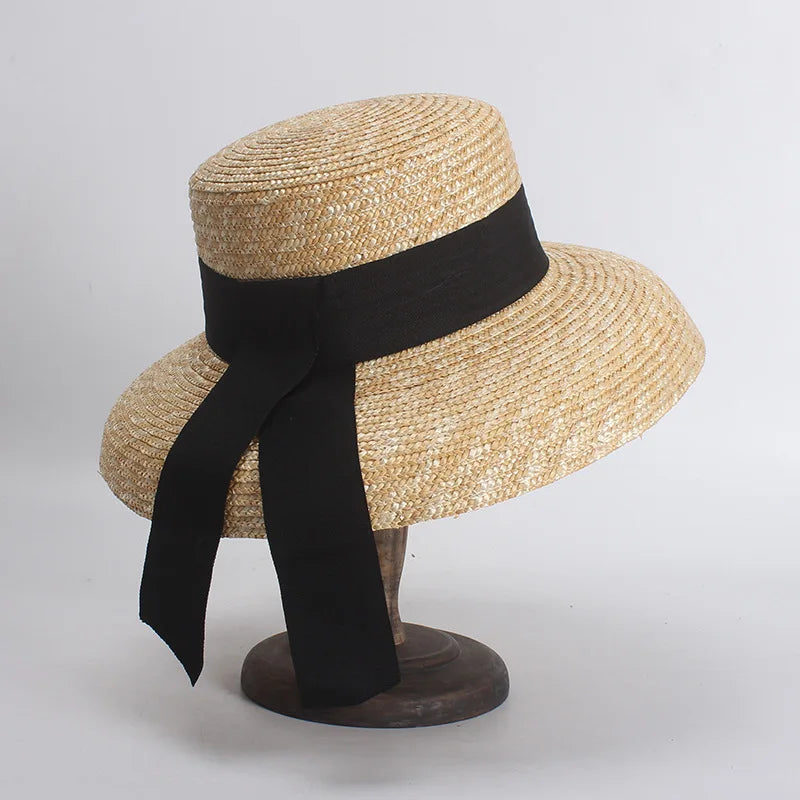 Straw hat with a black ribbon on a gray background