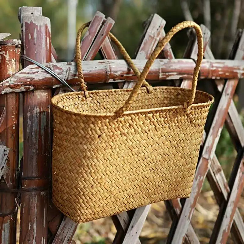 Woven basket hanging on a rustic wooden fence
