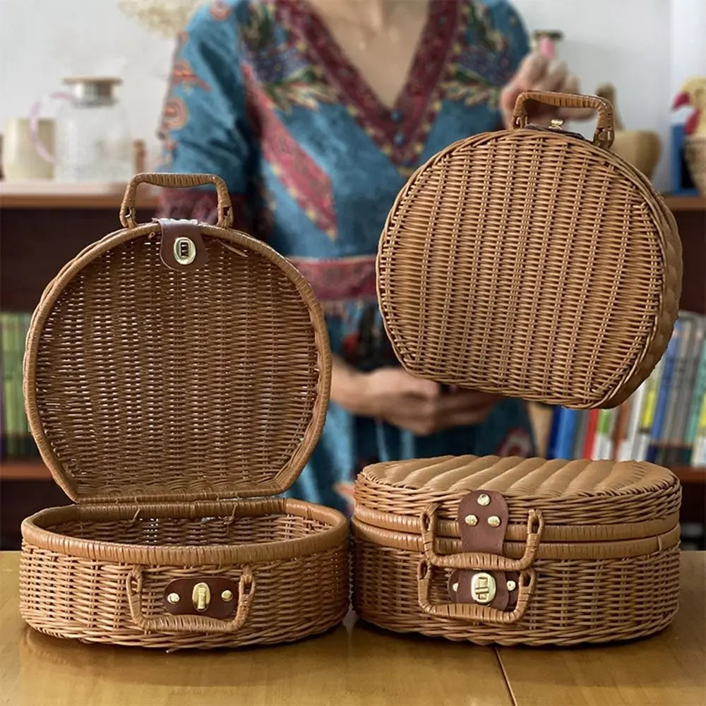 Three wicker suitcases of different sizes on a wooden surface with a blurred person in the background.