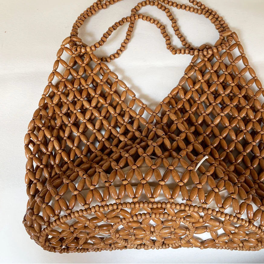 Brown woven handbag on a white background
