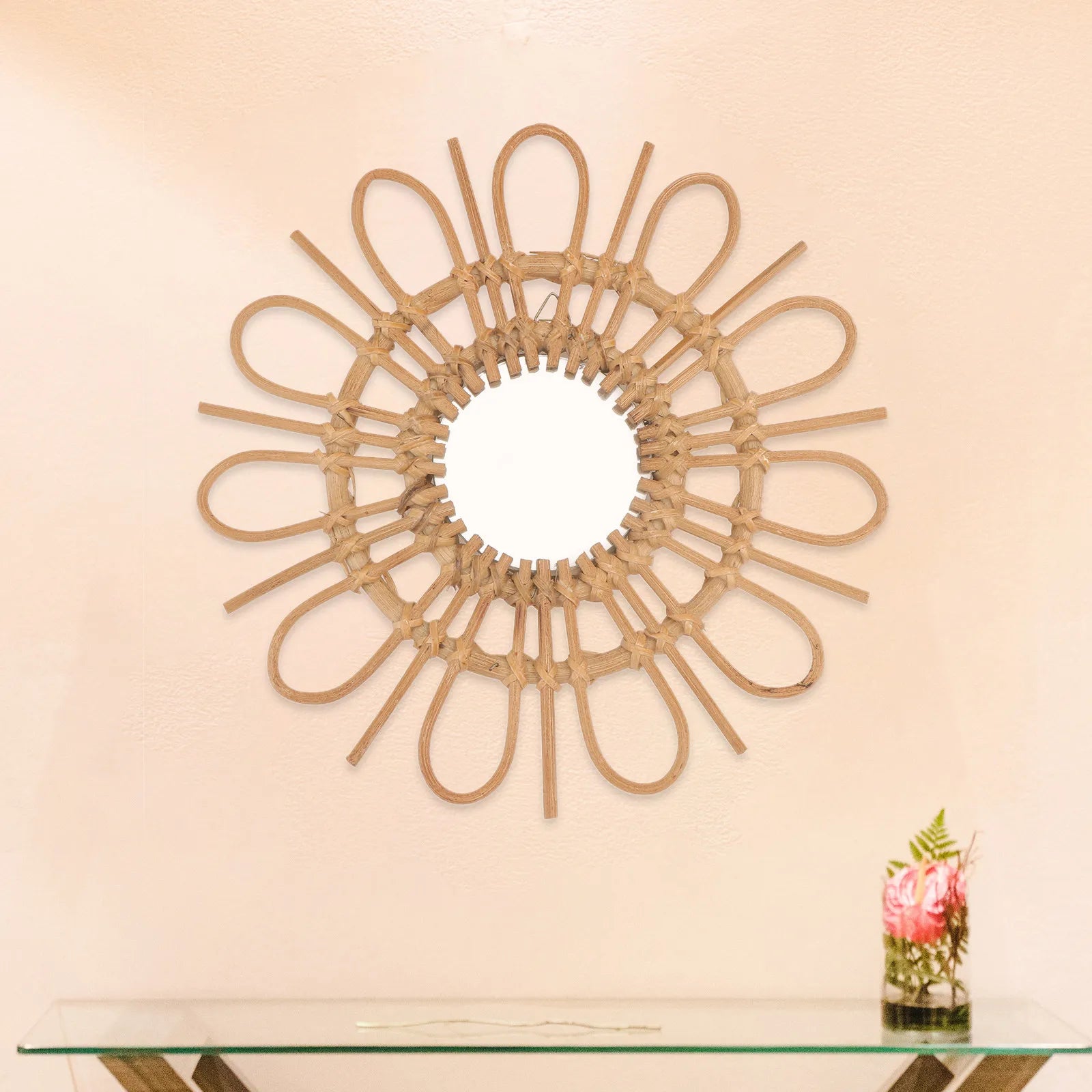 Decorative wall mirror with a sunburst design on a beige wall.
