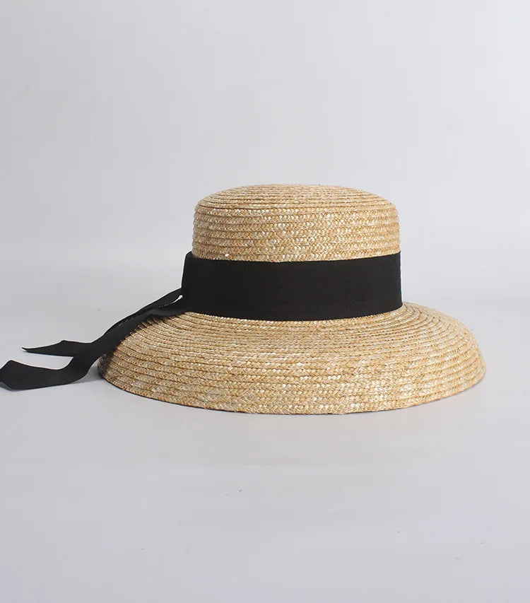 Straw hat with a black ribbon on a gray background
