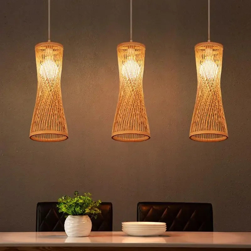Three woven pendant lights hanging above a dining table with chairs and decor.