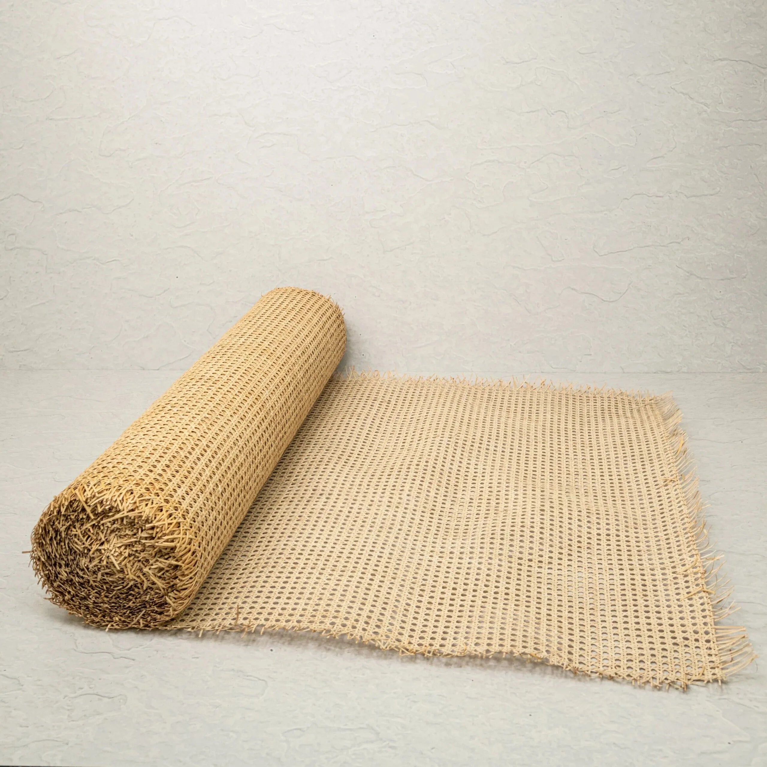 Rolled rattan web cane on a light gray background
