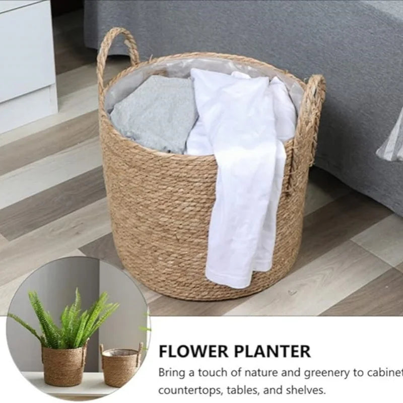 Woven basket with white towels inside, placed on a wooden floor with a plant in the corner.