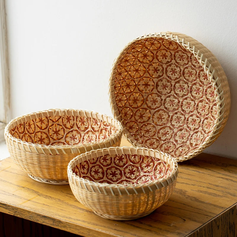Three woven baskets with geometric patterns on a wooden surface.
