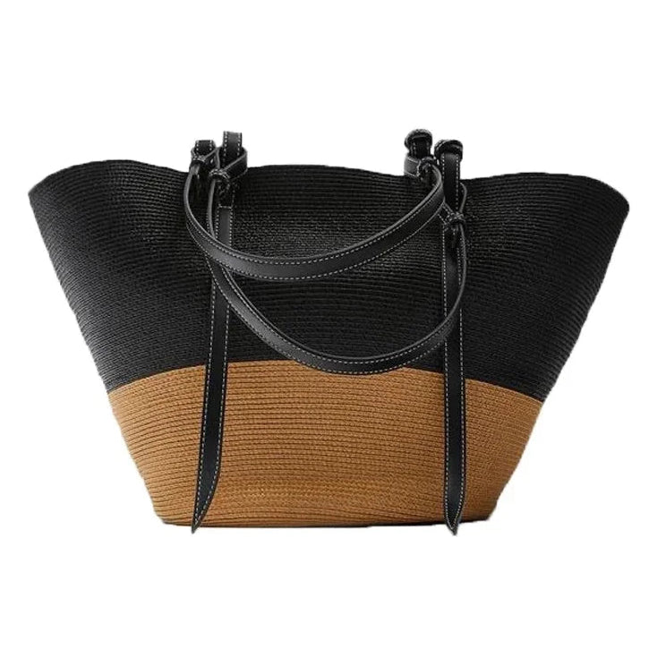 A two-tone woven straw tote bag with a black upper half and a tan lower half, featuring black leather shoulder straps, shown on a plain white background with the brand name 'YUE JABON' in the top left corner.