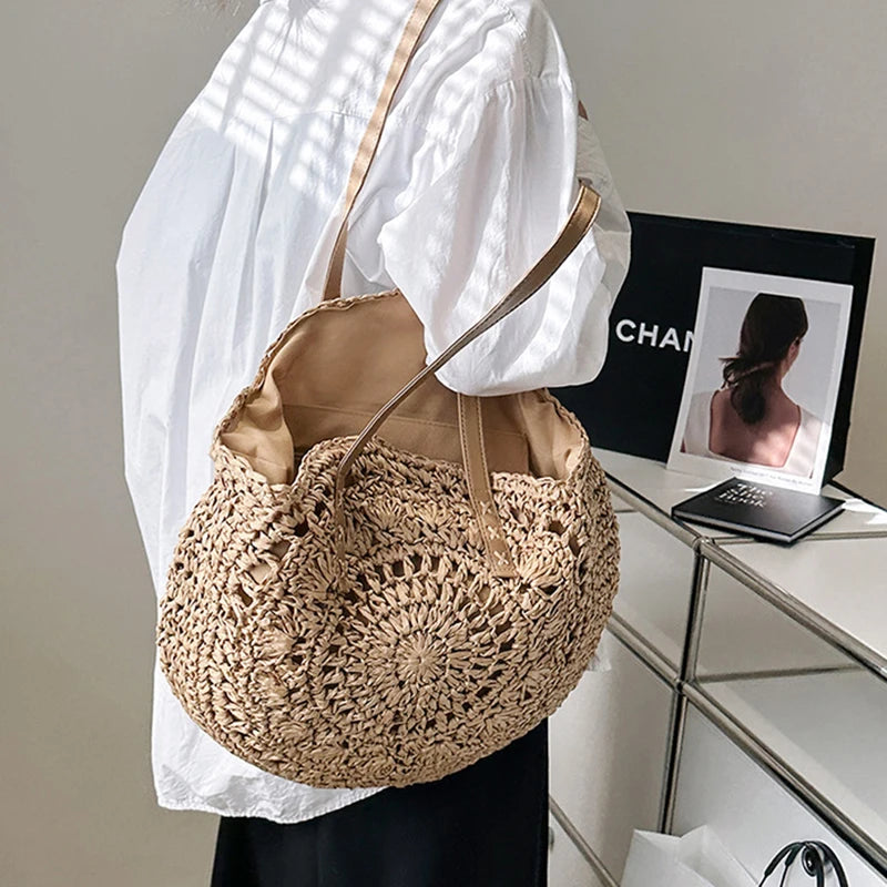 Person wearing a beige woven handbag with a white shirt and black pants, standing in front of a Chanel display.