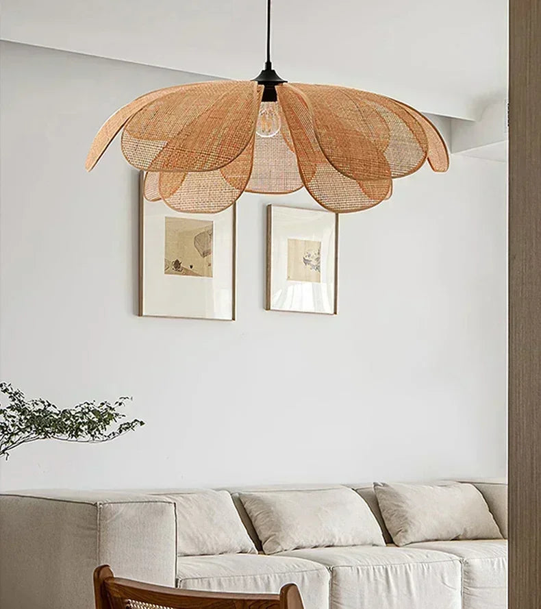 Woven pendant light fixture in a living room setting with a sofa and framed pictures on the wall.