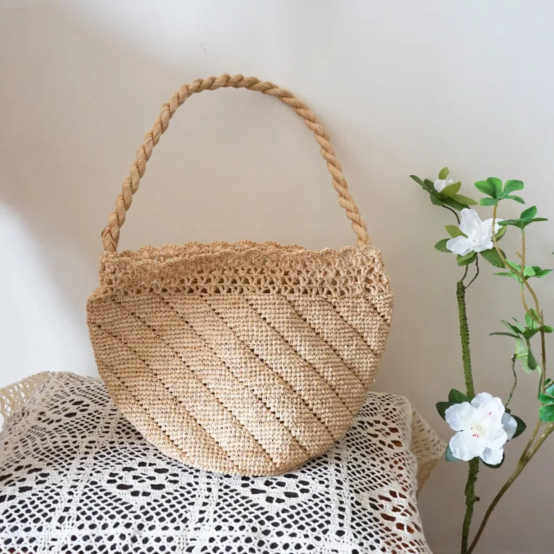 Woven basket with a handle on a textured surface next to a plant.