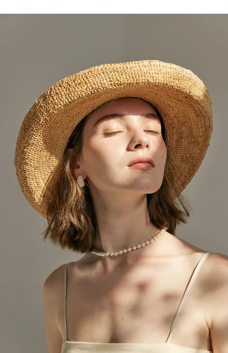 Woman wearing a straw hat against a neutral background