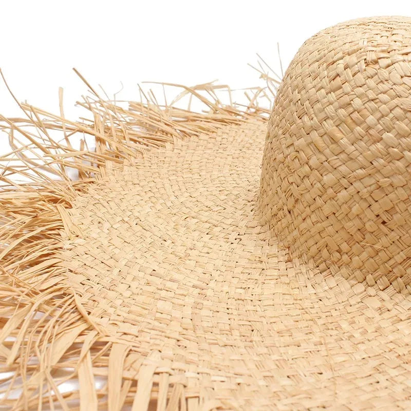 Close-up of a straw hat with fringes on a white background