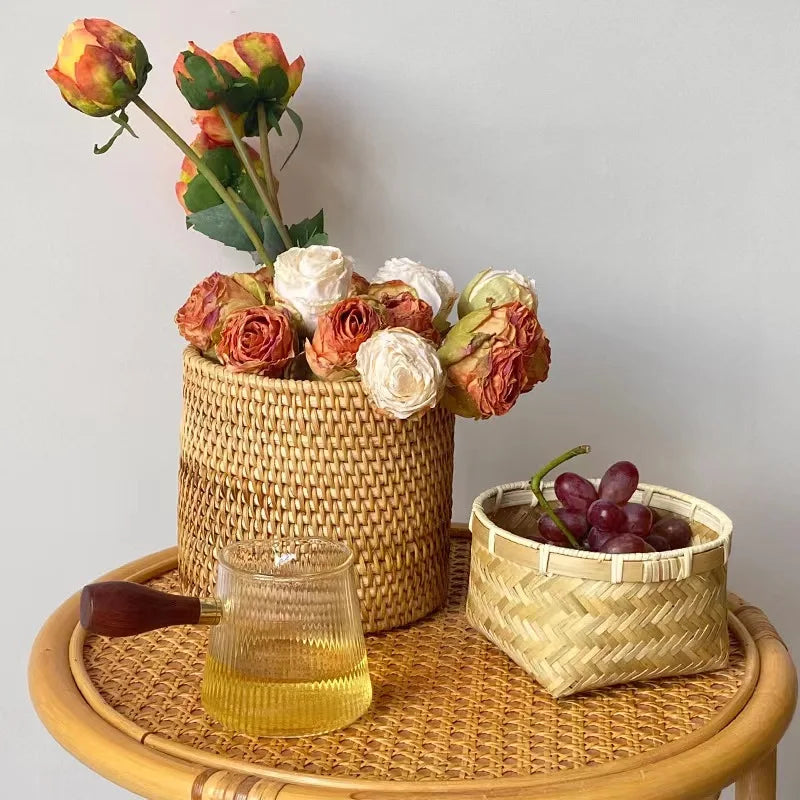 Wicker basket with flowers on a wooden tray against a light gray background