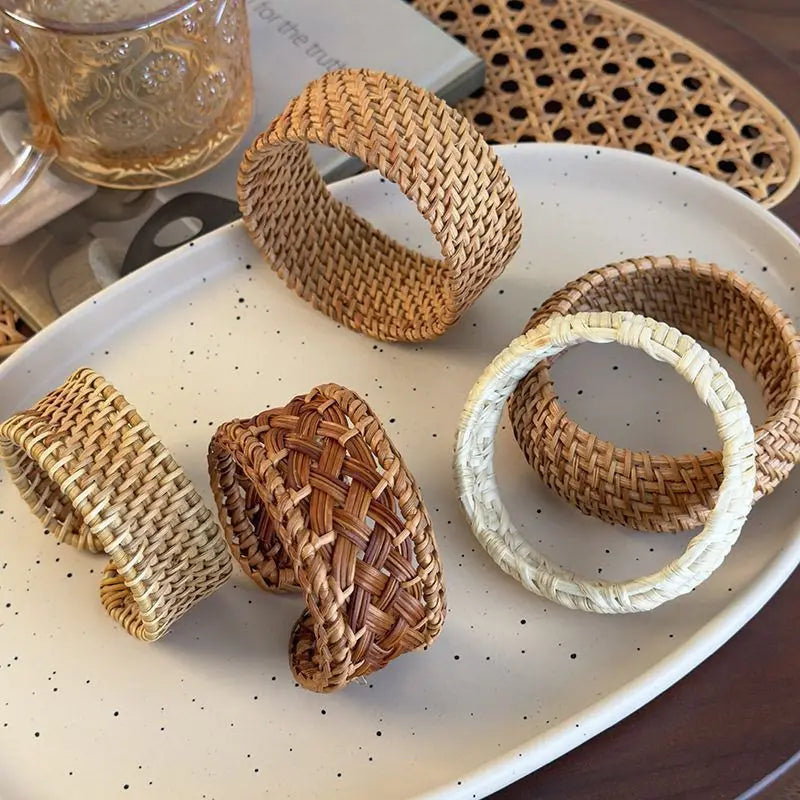 Woven rattan bracelets on a speckled ceramic plate with a blurred background