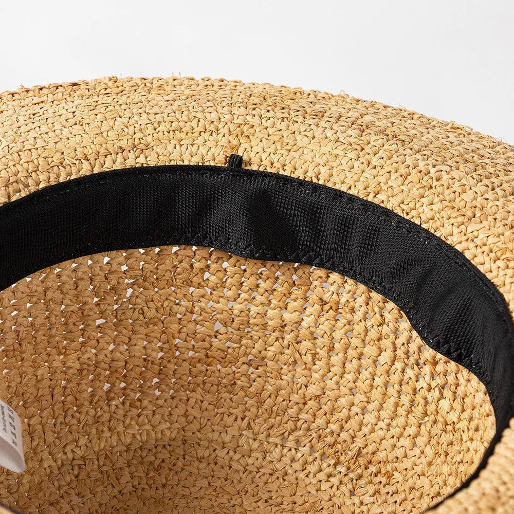 Close-up of a straw hat with a black band on a white background