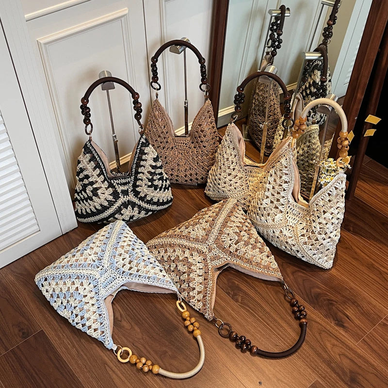Collection of woven handbags with decorative handles on a wooden floor.