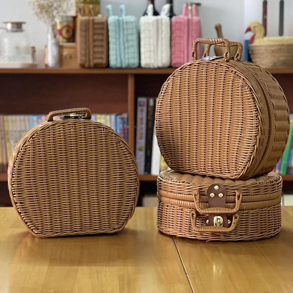 Three wicker picnic baskets of different sizes on a wooden surface.