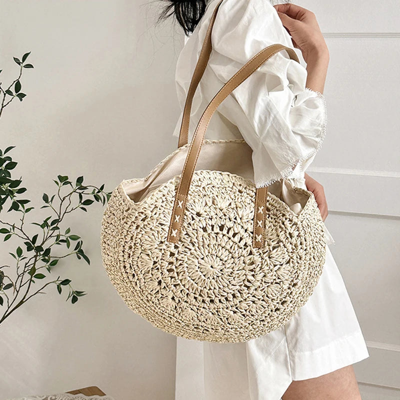 Person holding a woven beige bag with a neutral background