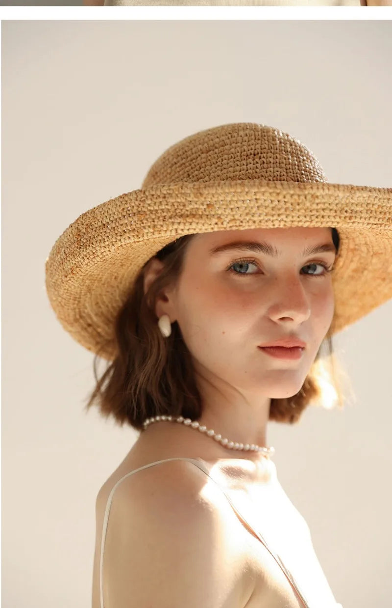 Woman wearing a straw hat against a plain background