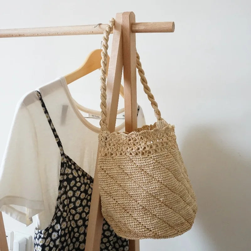 Woven bag hanging on a wooden hanger with a white background