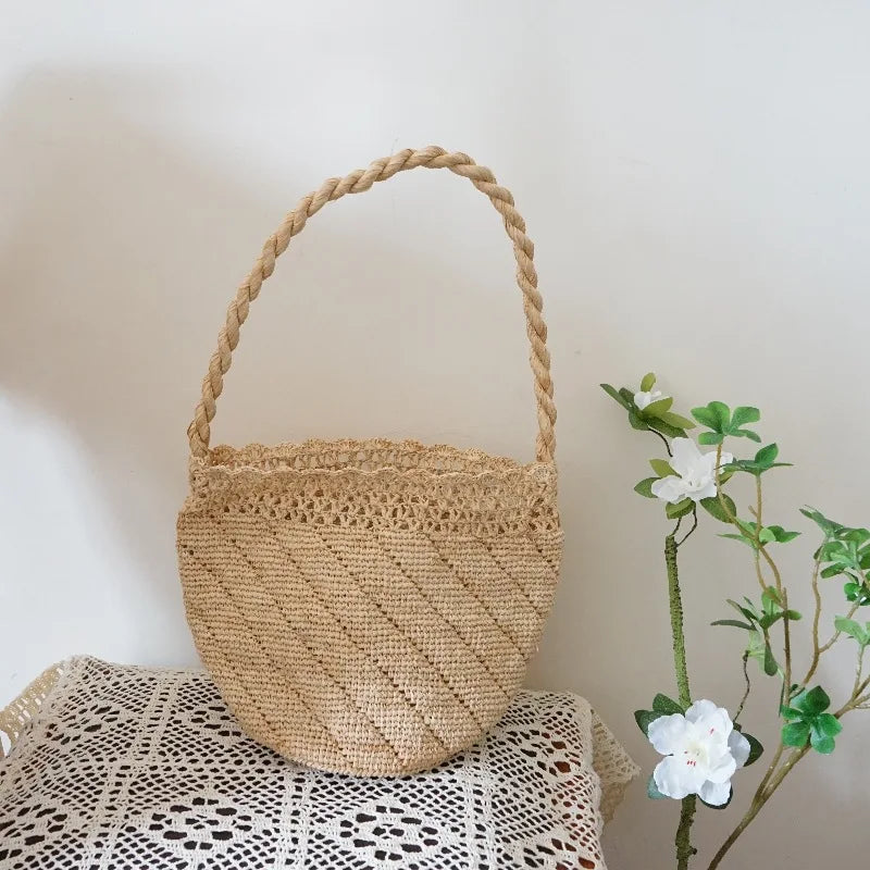 Woven basket with a handle on a textured surface with a plant in the background
